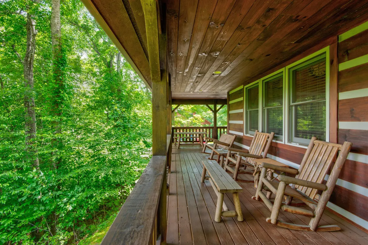 An inviting porch with wooden rocking chairs and a bench framed by lush greenery. The setting is intimate and peaceful, ideal for quiet conversations or unwinding after a day exploring local wineries and scenic drives.
