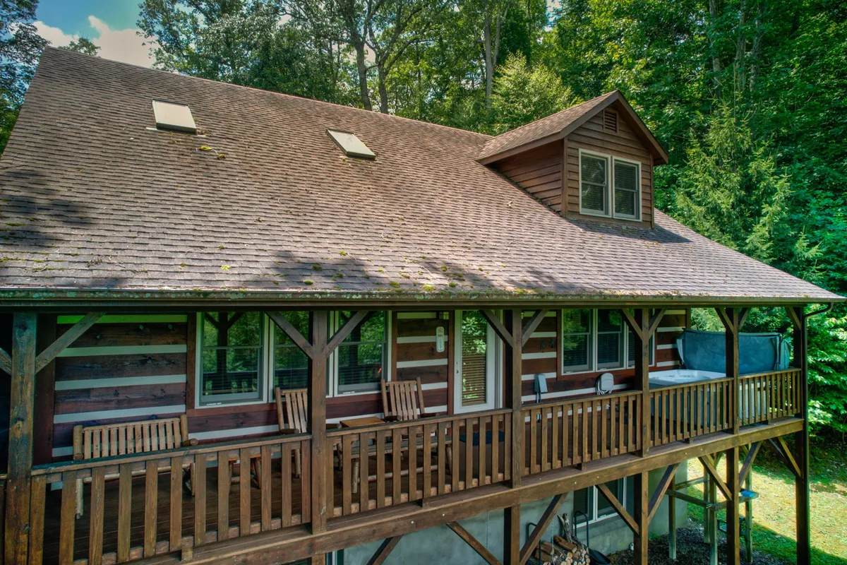 A welcoming wooden balcony with a sloped roof and large windows overlooking lush greenery. The space is tranquil and private, perfect for relaxing and enjoying the outdoors. The balcony suggests the seamless connection between the retreat and the surrounding natural beauty.